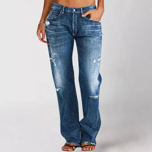 Blue jeans with slight distressing on a plain background
