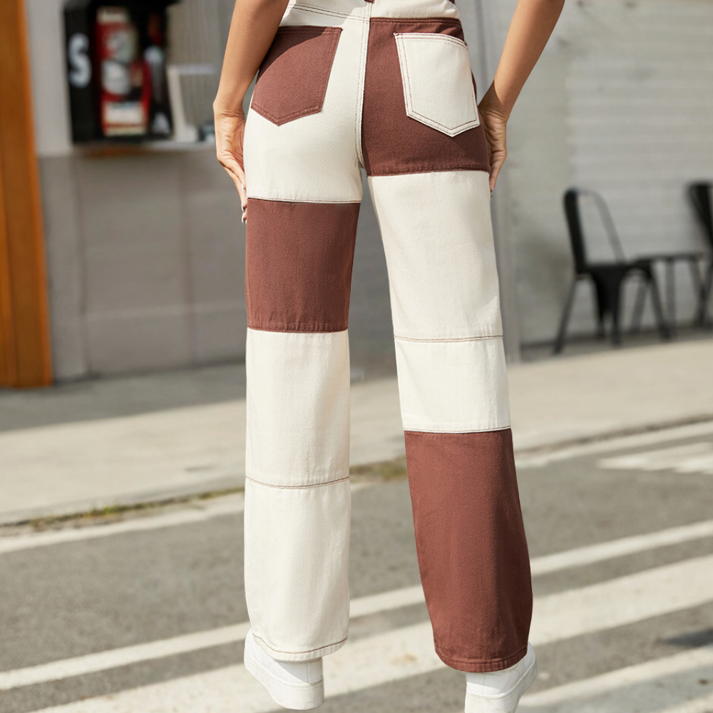 Person wearing a patchwork pants with brown and white colors on a street.