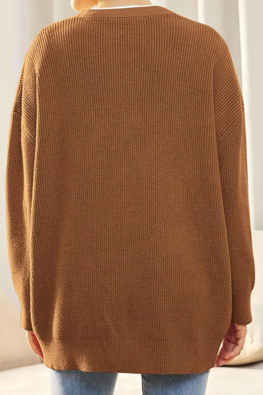Brown ribbed sweater worn by a person with a neutral background