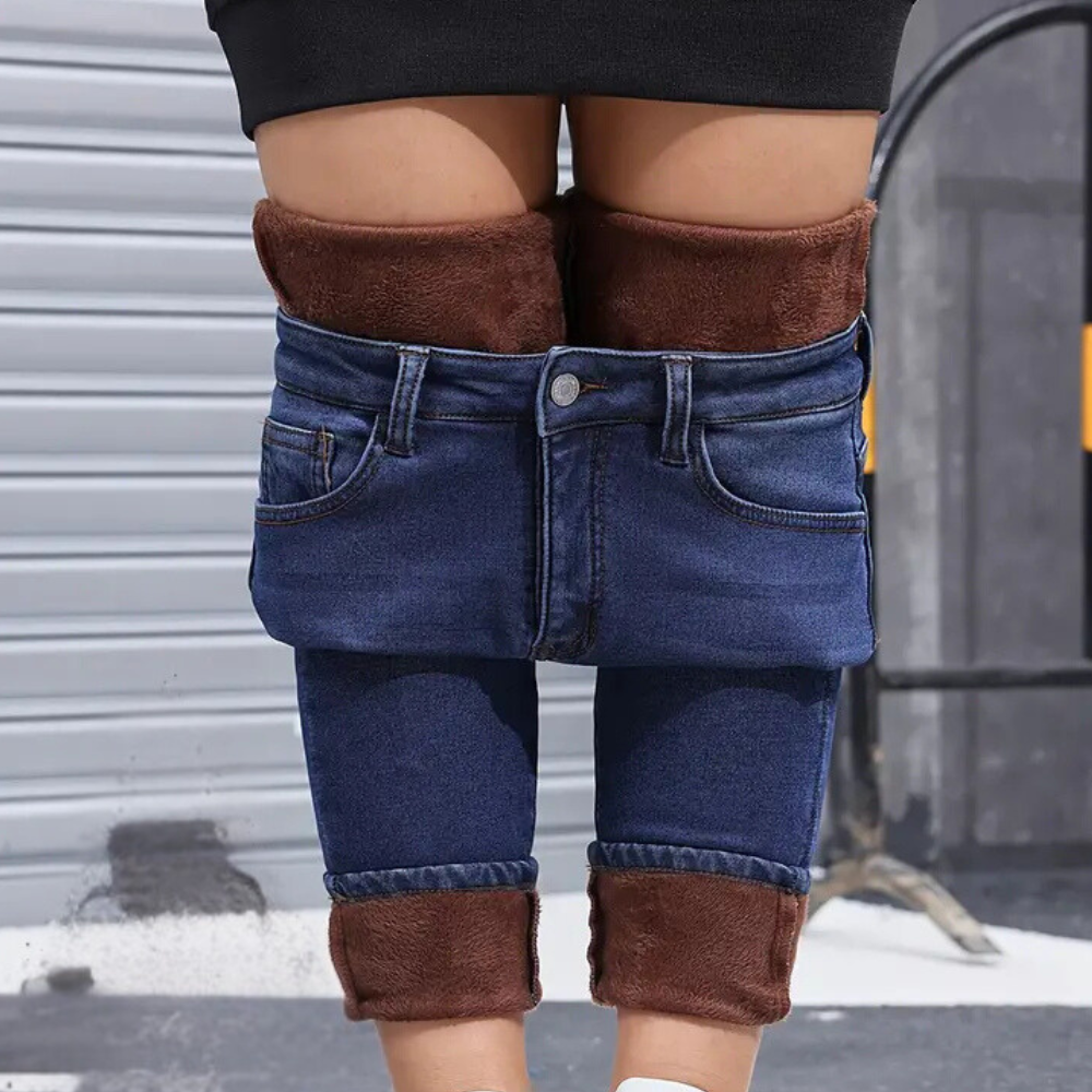 Person wearing blue jeans with brown cuffs in an urban setting