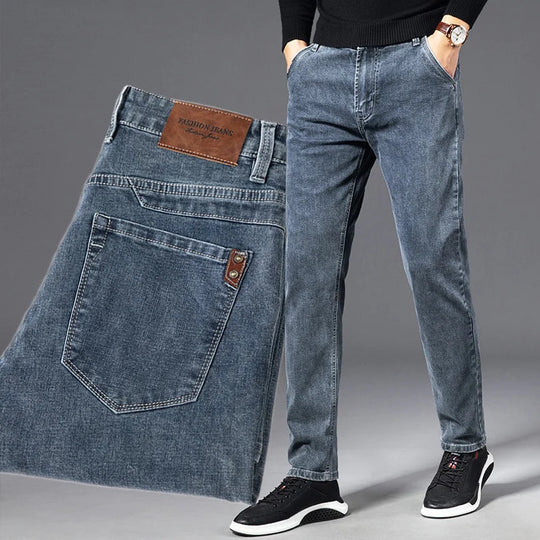 Blue jeans displayed with a person wearing them on a gray background