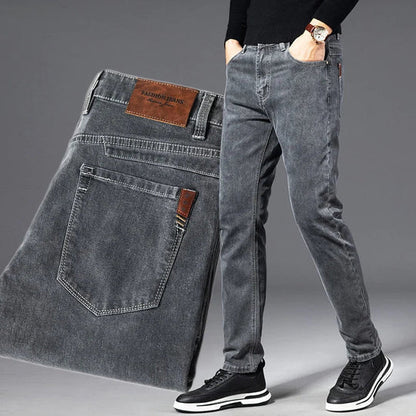 Gray jeans displayed with a person wearing them on a gray background