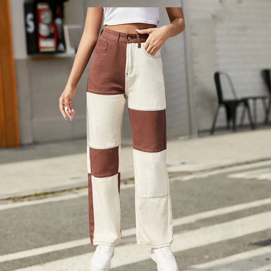 Person wearing a two-tone brown and white pants on a street.