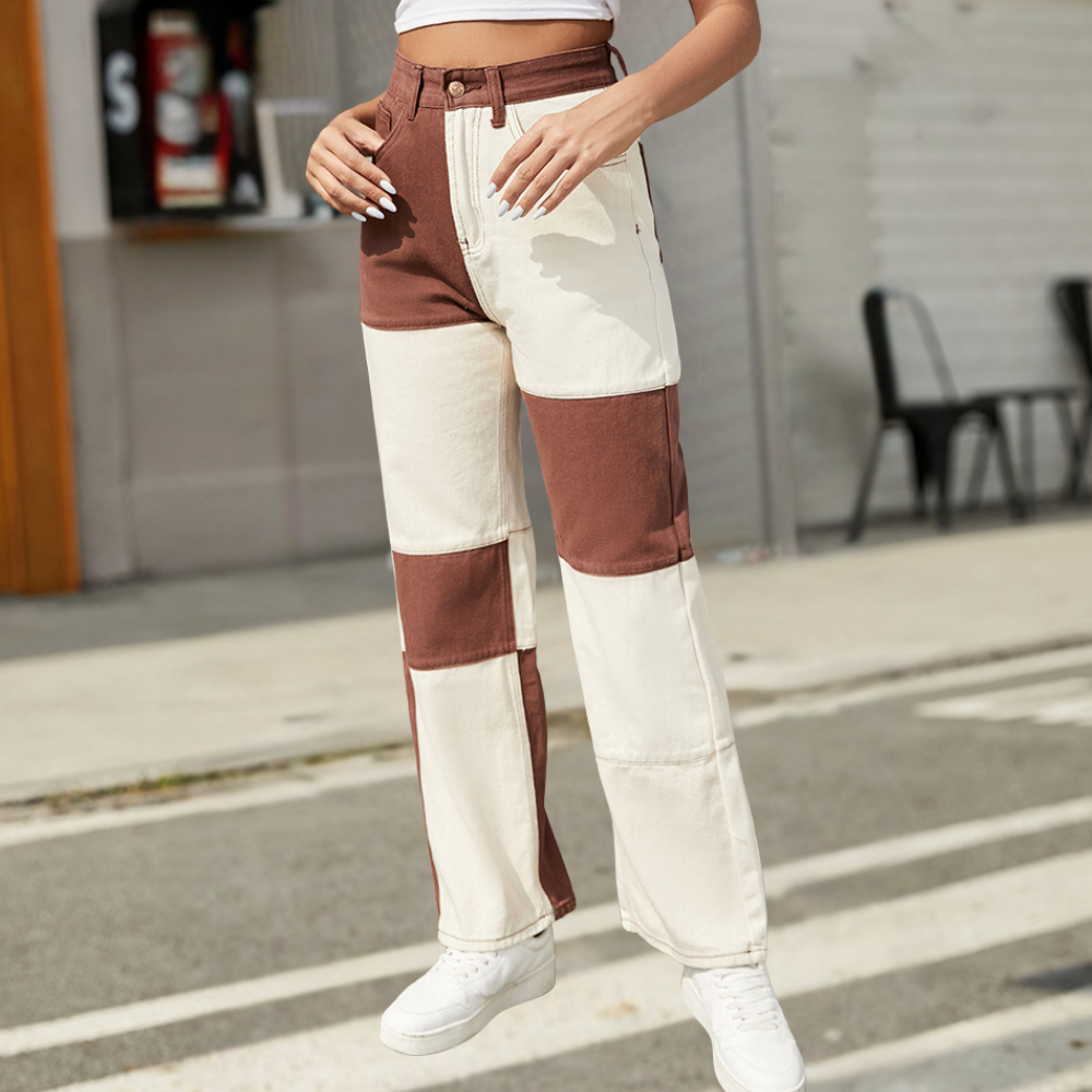 Person wearing a brown and white striped pants on a street.