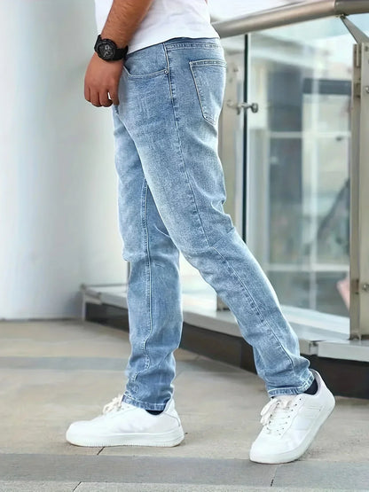 Person wearing light blue jeans and white sneakers in an urban setting