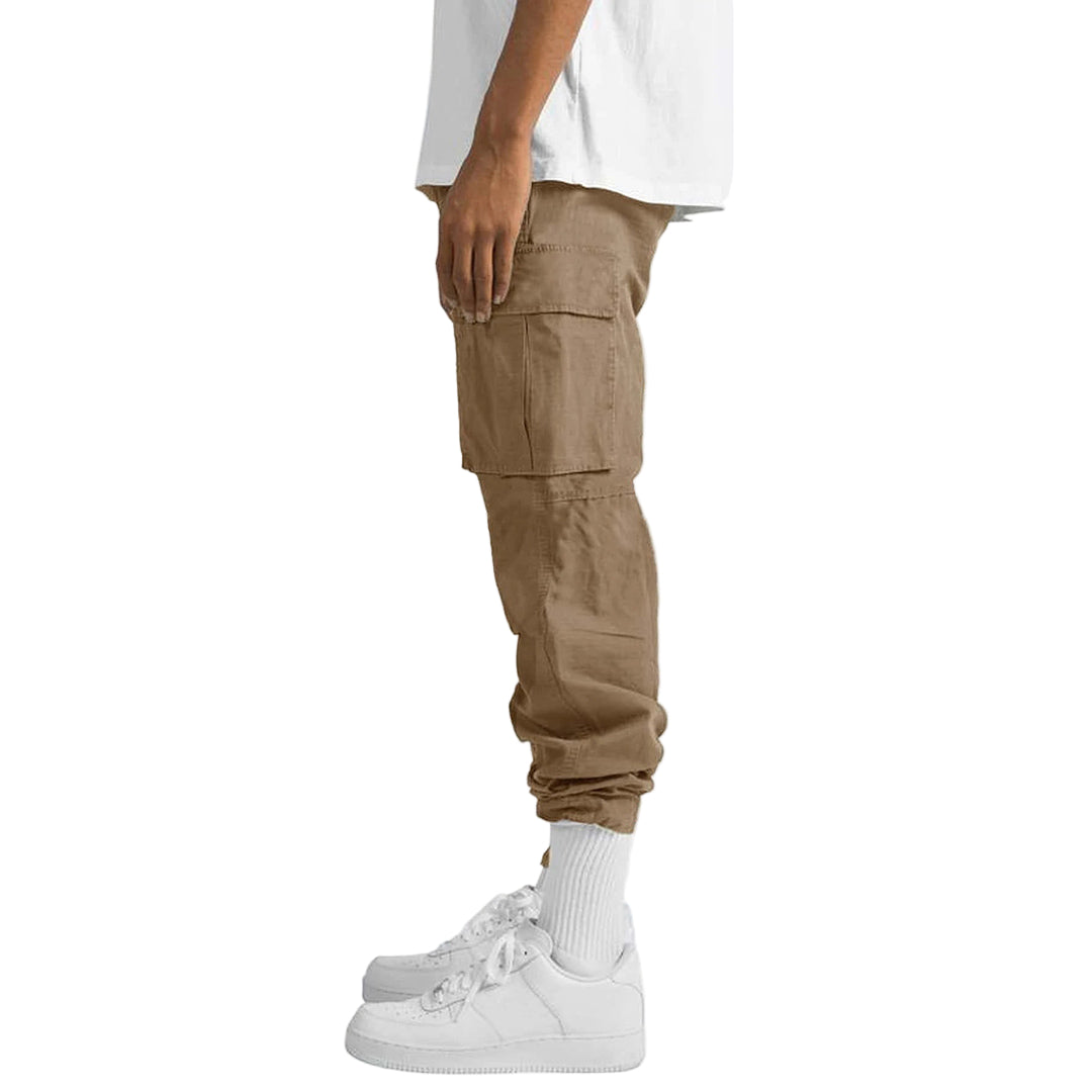 Person wearing beige cargo jogger pants with a white shirt and white sneakers on a light gray background
