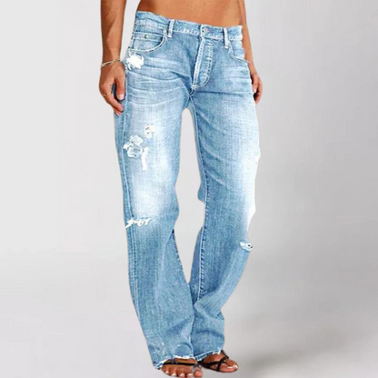 Light blue distressed jeans worn by a person on a plain background