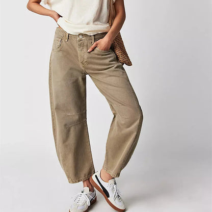Person wearing beige pants and white sneakers on a plain background