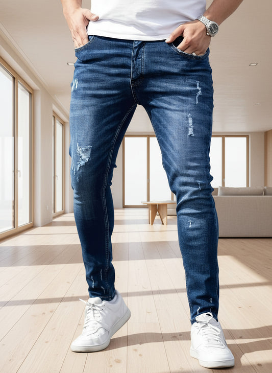 Person wearing blue jeans and white sneakers on a road.