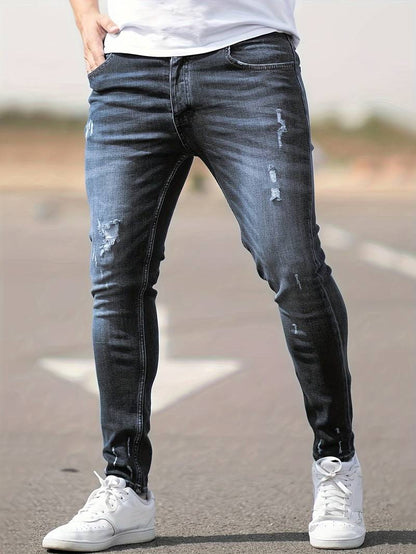 Person wearing distressed black jeans and white sneakers on a blurred background
