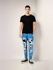 Man wearing a black t-shirt and blue jeans with white patterns on a plain background