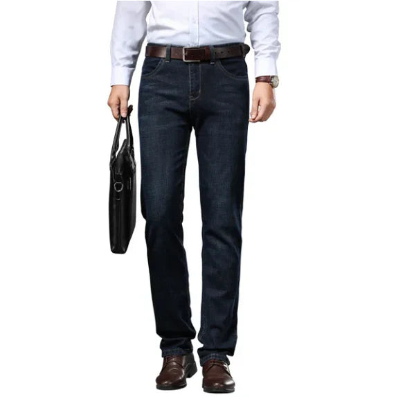 Person wearing dark blue jeans with a white shirt and brown belt on a white background