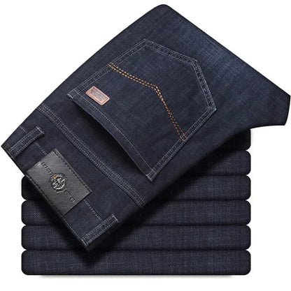 Stack of folded dark blue jeans on a white background