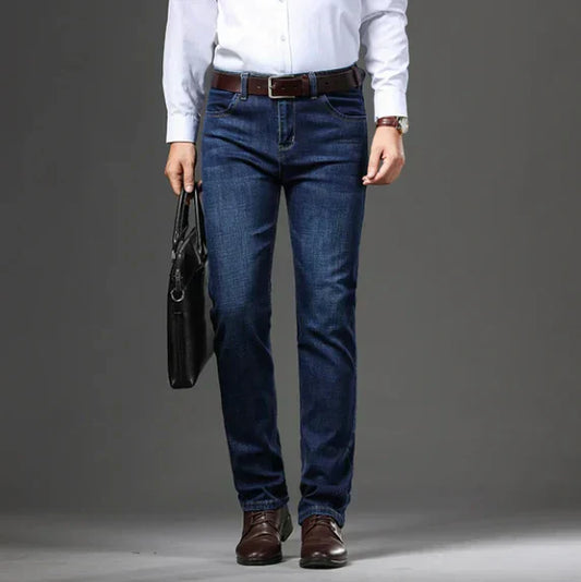 Person wearing blue jeans and a white shirt with a gray background