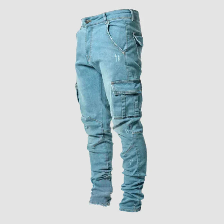 Light blue jeans with multiple pockets on a light gray background