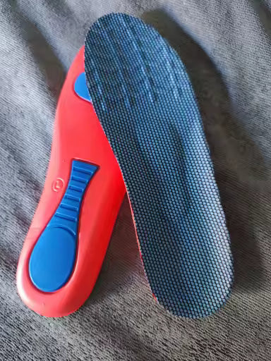 Red and blue shoe insole on a gray fabric background